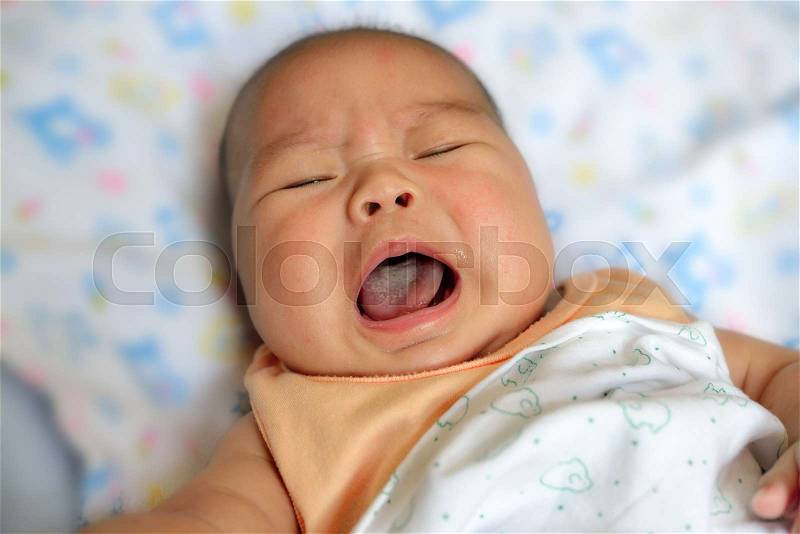 New born asian baby crying on bed, stock photo