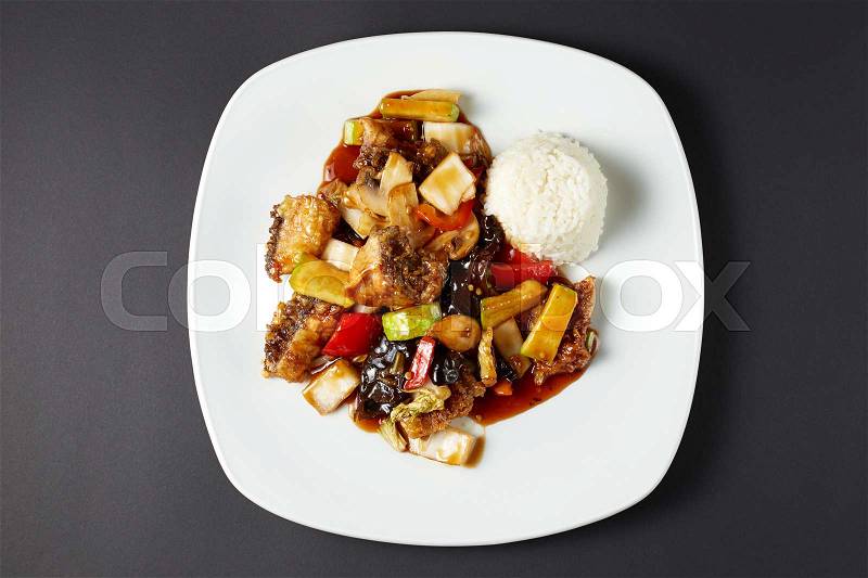 Carp in sweet and sour sauce. Asian food. Asian cuisine. Studio shot on dark or black background, stock photo