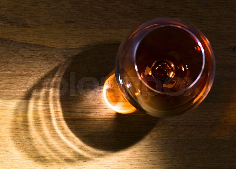 Snifter of brandy on a wooden table . Top view , stock photo