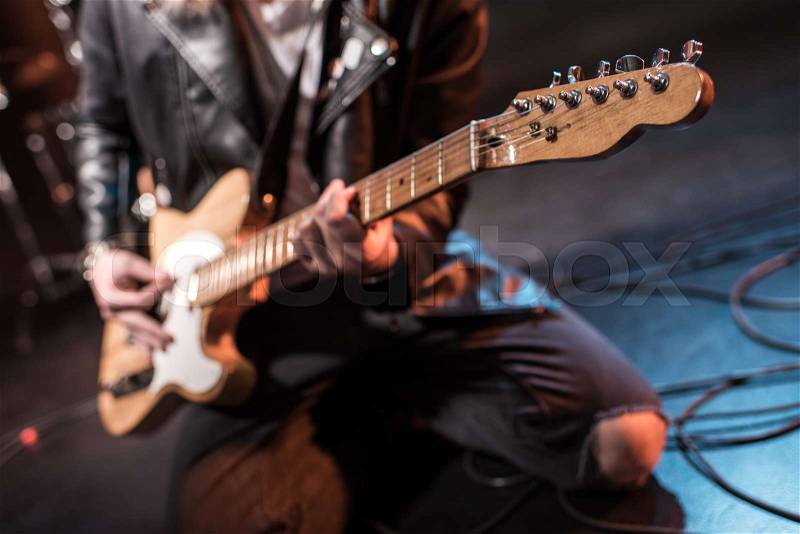 Close-up partial view of rock star playing hard rock music on stage , stock photo