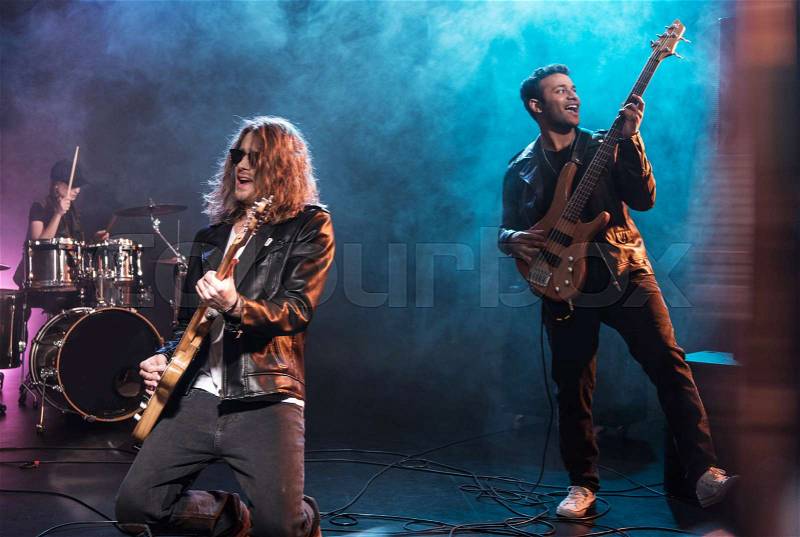 Electric guitar players with rock and roll band performing hard rock music on stage , stock photo