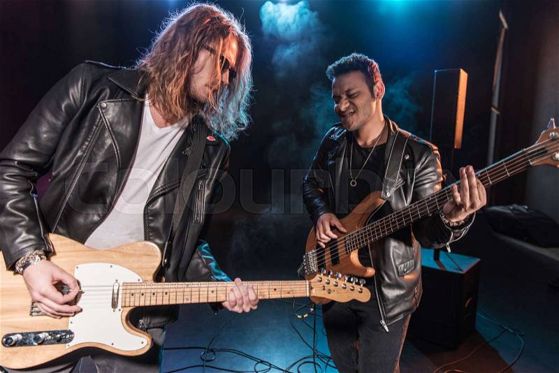 Electric guitar players performing hard rock music on stage , stock photo