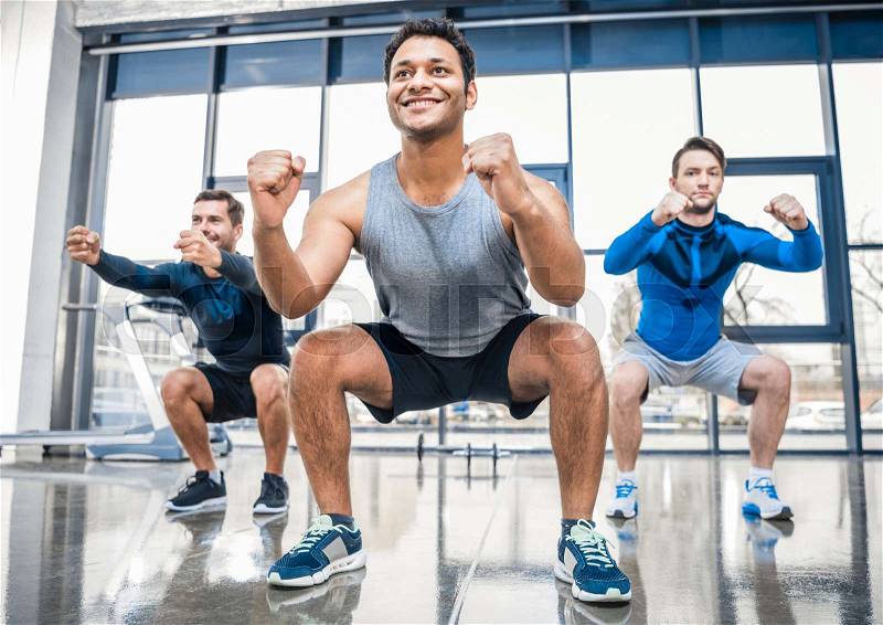 Young men exercising at sports center, stock photo