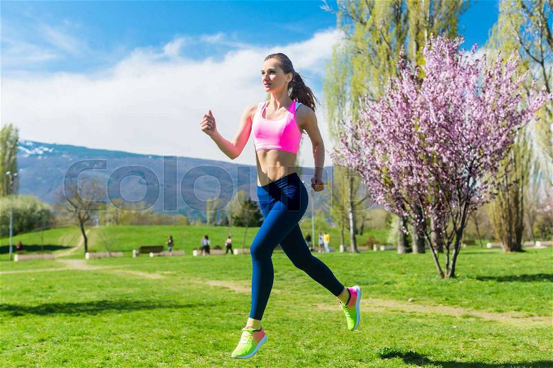 Woman running fast for sport on sunny day, stock photo