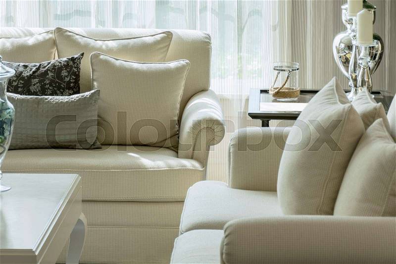 White and gray decorative pillows on a casual sofa in the living room, stock photo