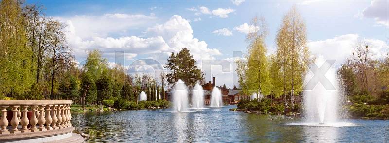Ornamental gardens with lake, blooming bushes and fountains. Banner for website, stock photo