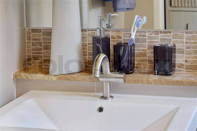 Washbasin with faucet ,toothbrush and liquid soap bottle at home, stock photo