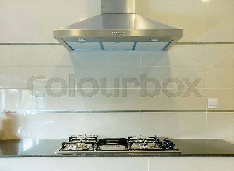 Cooking gas stove with hood in modern kitchen, stock photo