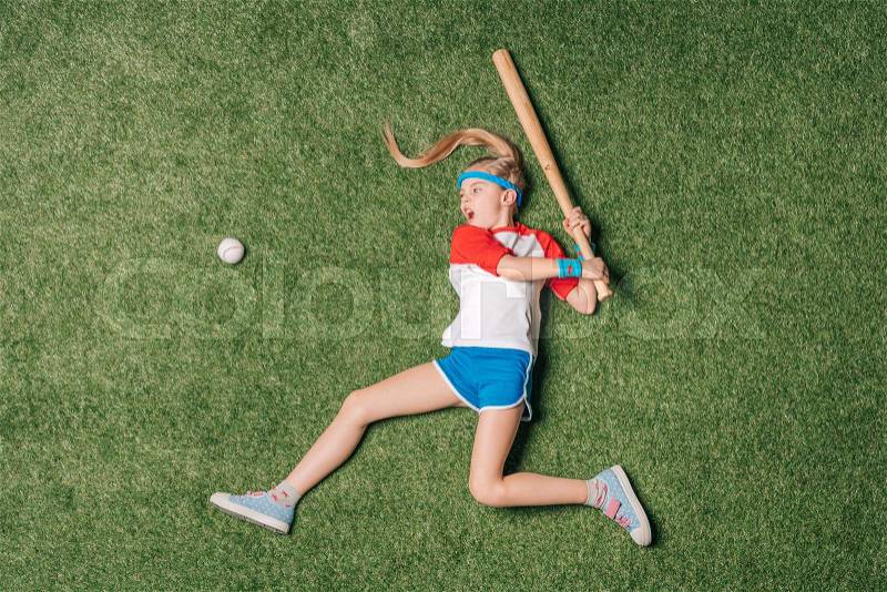 Top view of little girl pretending playing baseball on grass, athletics children concept, stock photo