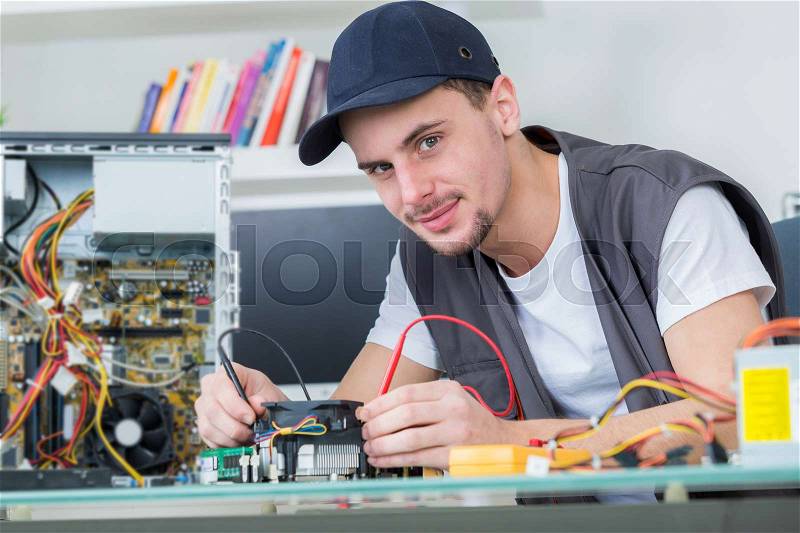 Young male tech tests electronic equipment, stock photo