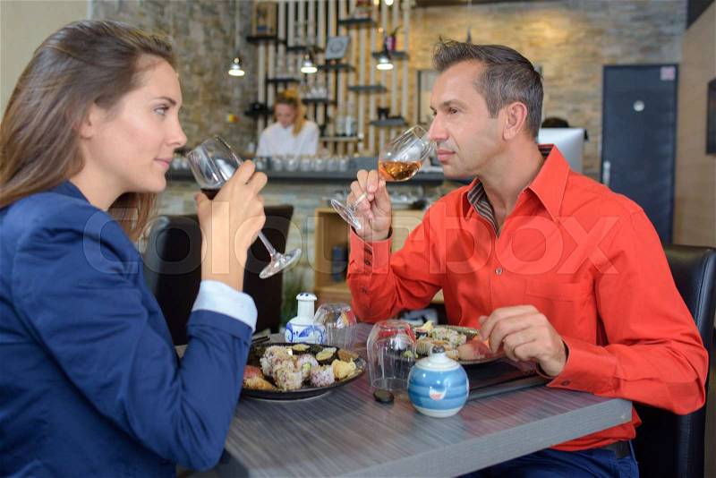 Couple in restaurant smelling wines, stock photo