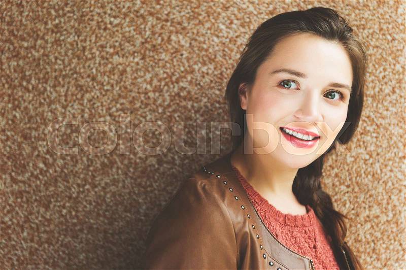 Close up portrait of beautiful young 25-30 year old woman with professional make up, wearing brown leather jacket, stock photo