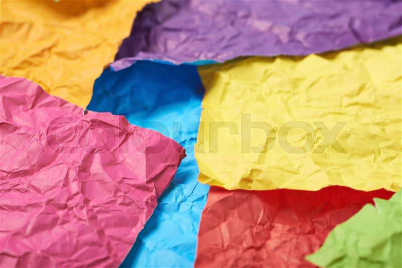 Surface coated with the multiple colorful crumpled origami paper sheets as an abstract background composition, stock photo