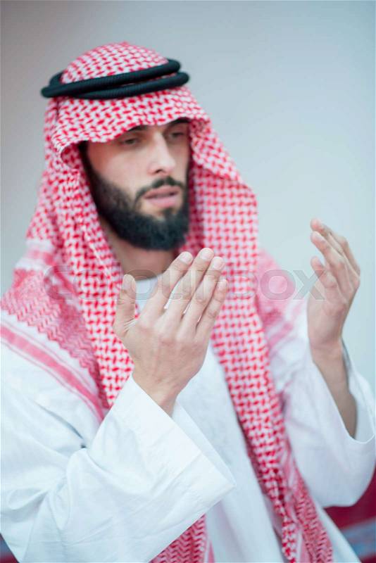 Handsome Younger Muslim Arabic man praying in mosque, stock photo