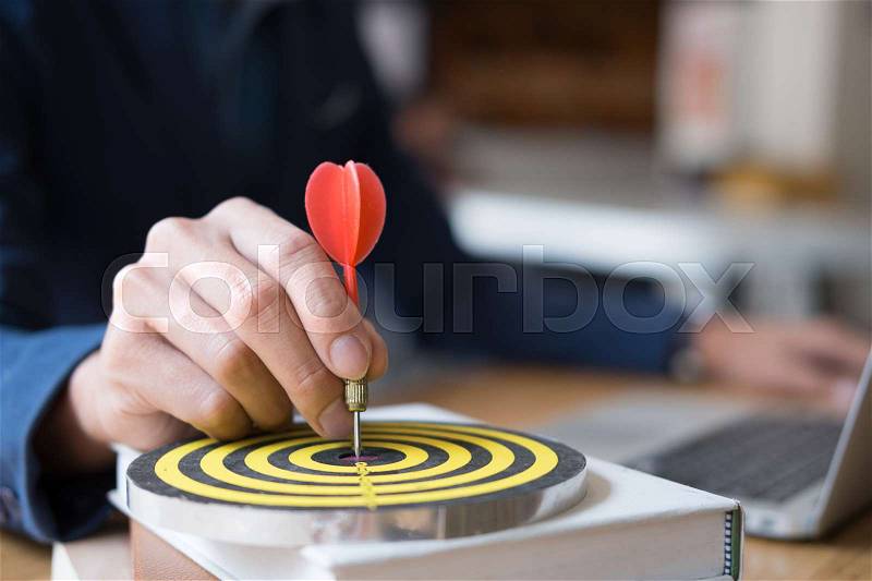 Business Man hand holding a target with darts hitting the center. Concept of personal coaching success. Concept of objective attainment, stock photo