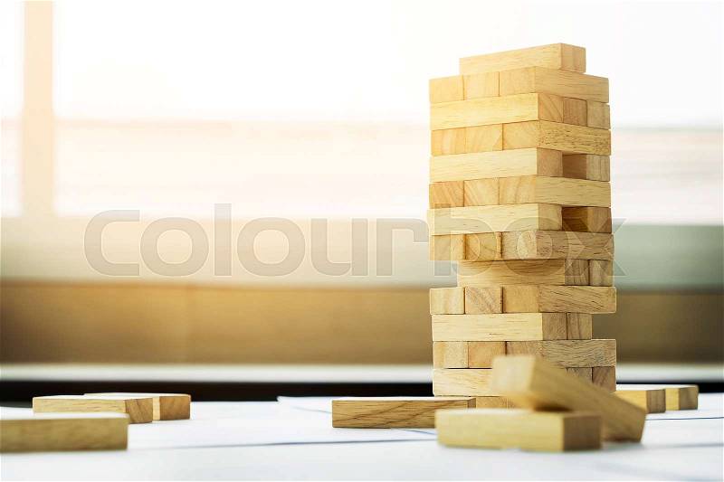 The blocks wood tower game with architectural engineer plans or blue prints compasses ,pencils and ruler on wooden table, plan and building concept, stock photo