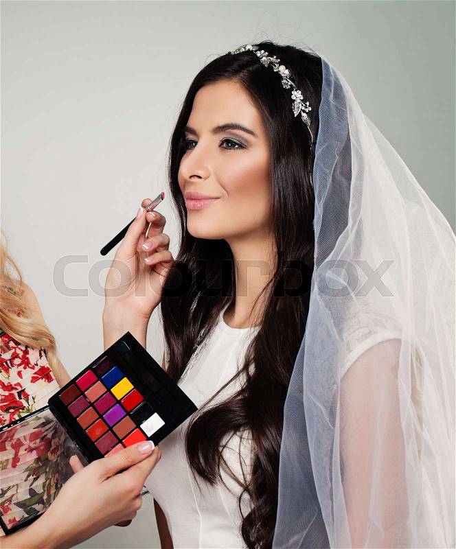 Bridal Makeup. Perfect Bride with Wedding Make up, Long Curly Hair and White Veil, stock photo
