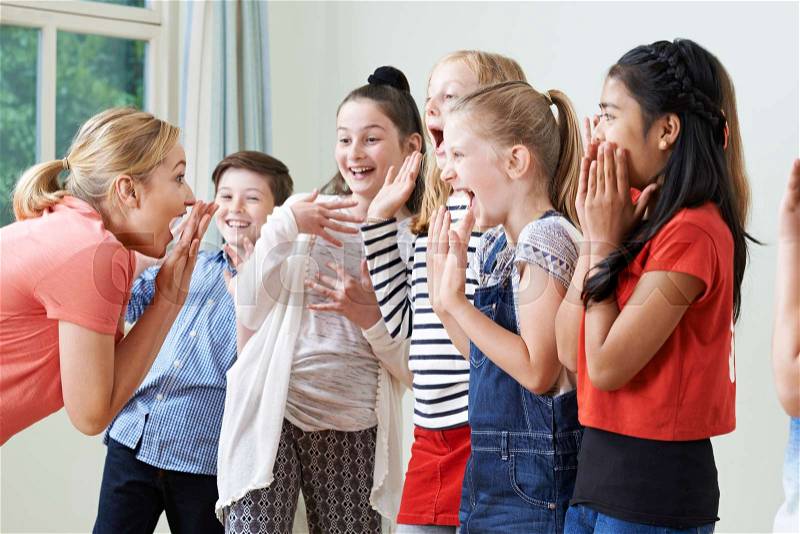 Group Of Children With Teacher Enjoying Drama Class Together, stock photo