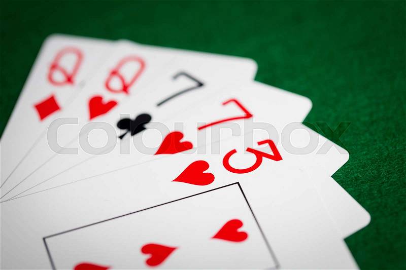 Casino, gambling, games of chance, hazard and entertainment concept - poker hand of playing cards on green cloth, stock photo