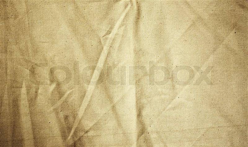 Background of crumpled dense fabric colored in beige tones, stock photo