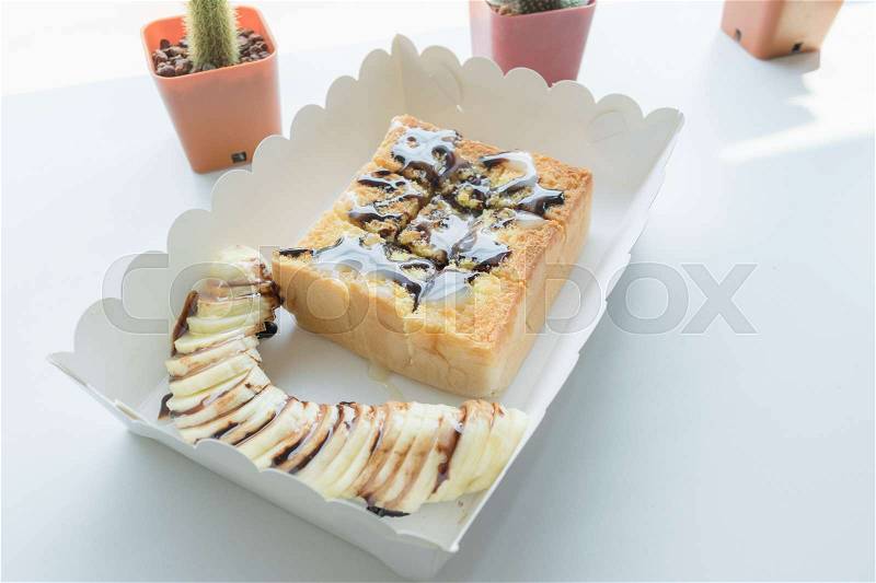 Morning toast with banana, topping by caramel and milk, stock photo