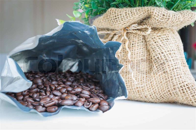 Coffee beans in bag of aluminum foil with sack, stock photo