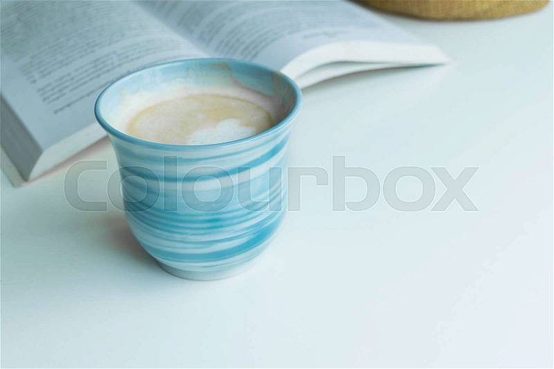 Blue coffee cup on the desk with books. Concept coffee lover background, stock photo