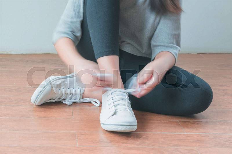 Beautiful little girl is tied up with a shoelace, stock photo