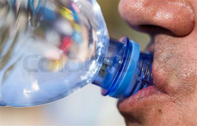 Man drinks water from a plastic bottle , stock photo