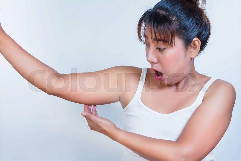 Asian woman checking her fat upper arm and she agape, stock photo
