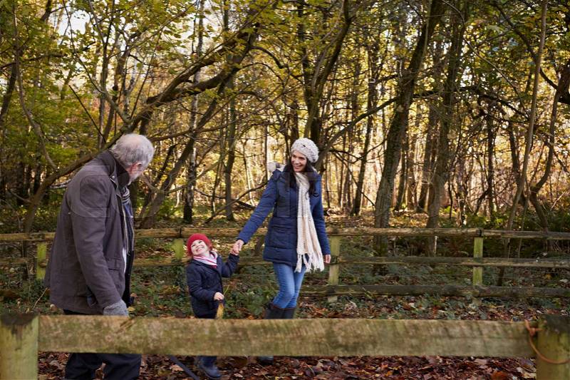 Multi Generation Family Enjoying Walk In Fall Landscape, stock photo
