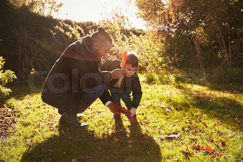 Boy And Father Playing With Autumn Leaves in Garden, stock photo