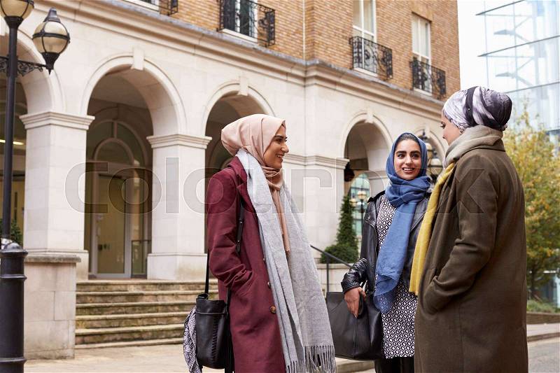 British Muslim Female Friends Meeting In Urban Environment, stock photo