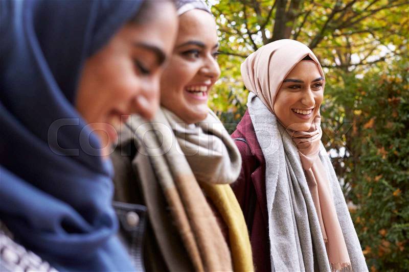 British Muslim Female Friends Meeting In Urban Environment, stock photo