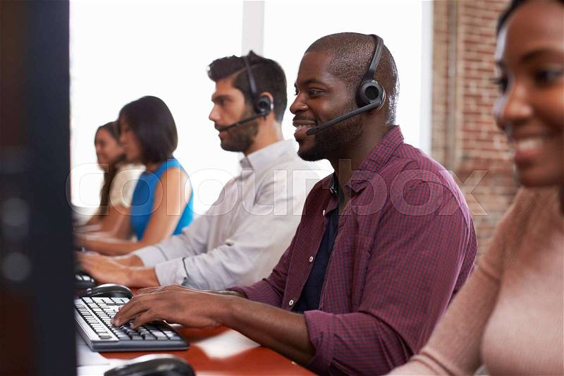 Staff Working In Busy Customer Service Department Shot, stock photo