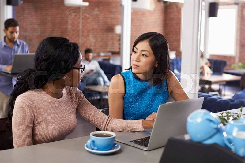 Two Businesswomen Have Informal Meeting In Office Coffee Bar, stock photo