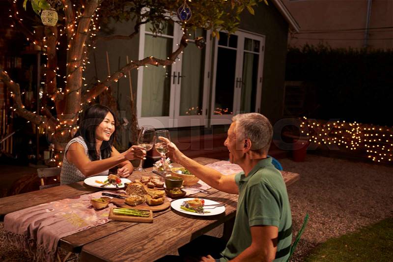 Mature Couple Enjoying Outdoor Meal In Backyard, stock photo