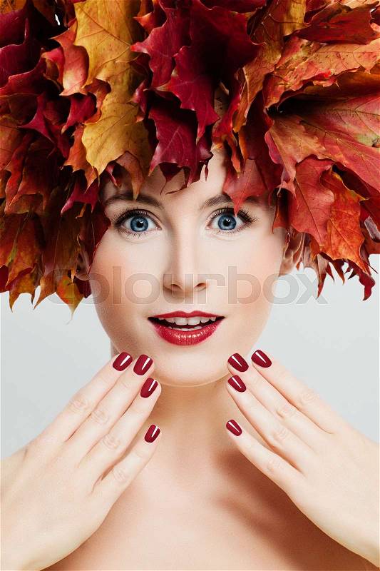 Autumn Makeup. Beautiful Woman with Fashion Makeup, Manicure Hands and Fall Leaves Wreath. Face Closeup, stock photo