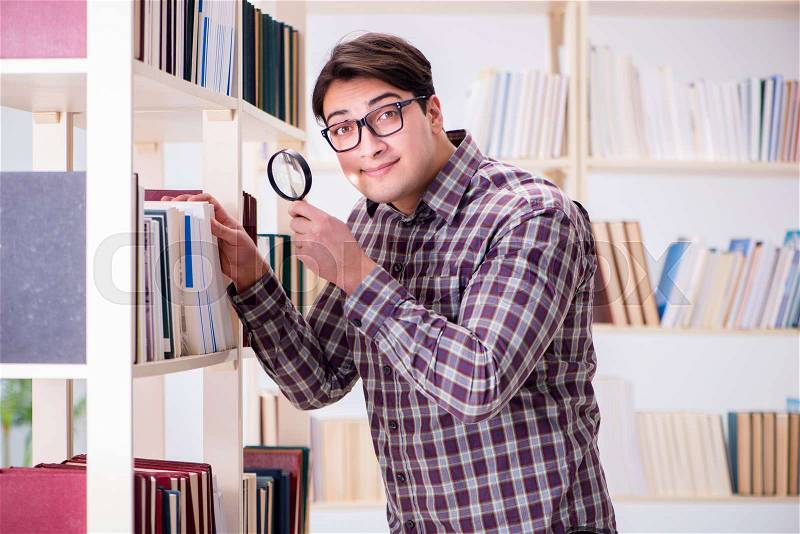 The young student looking for books in college library, stock photo
