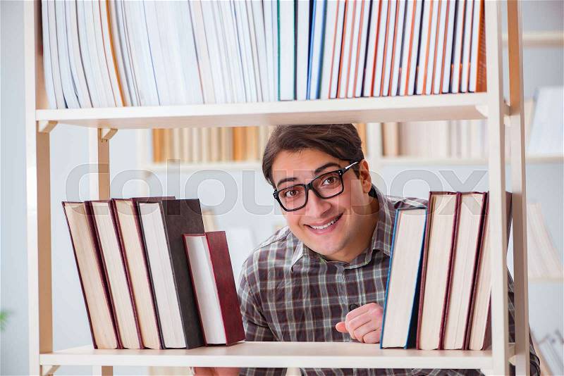 The young student looking for books in college library, stock photo