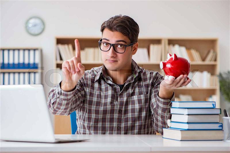The young student breaking piggy bank to buy textbooks, stock photo