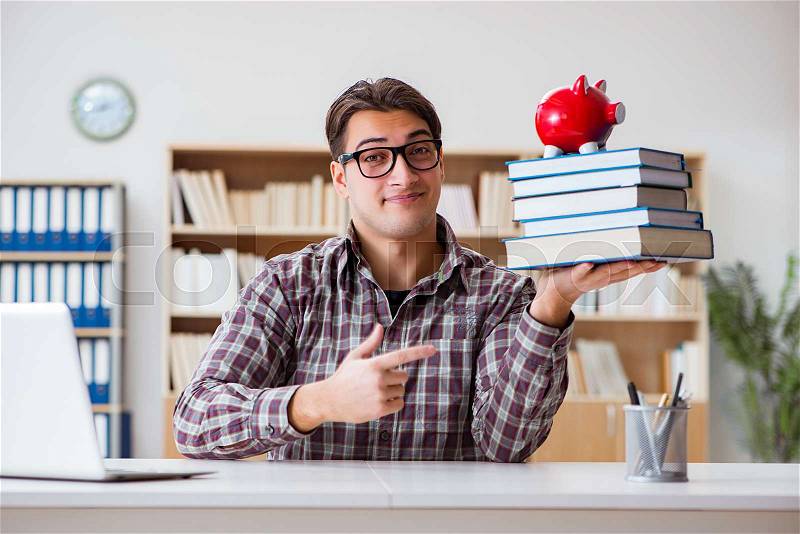 The student breaking piggybank to pay for tuition fees, stock photo