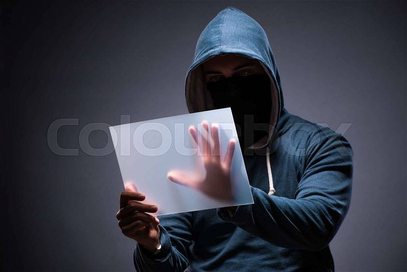 The hacker working on tablet in dark, stock photo