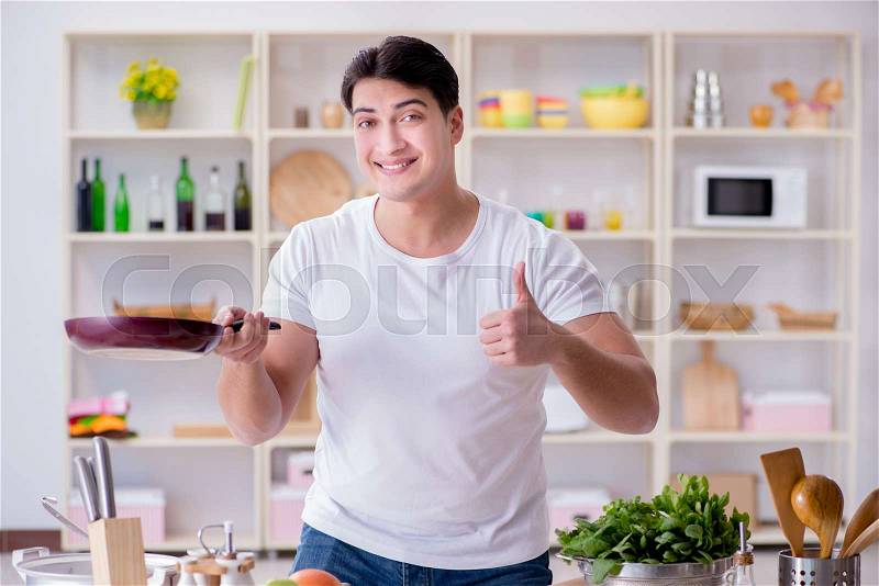 The young male cook working in the kitchen, stock photo