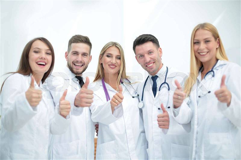 Smiling team of doctors at hospital making selfie and showing th, stock photo