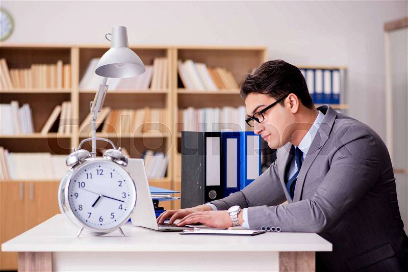 The businessman with clock failing to meet deadlines, stock photo