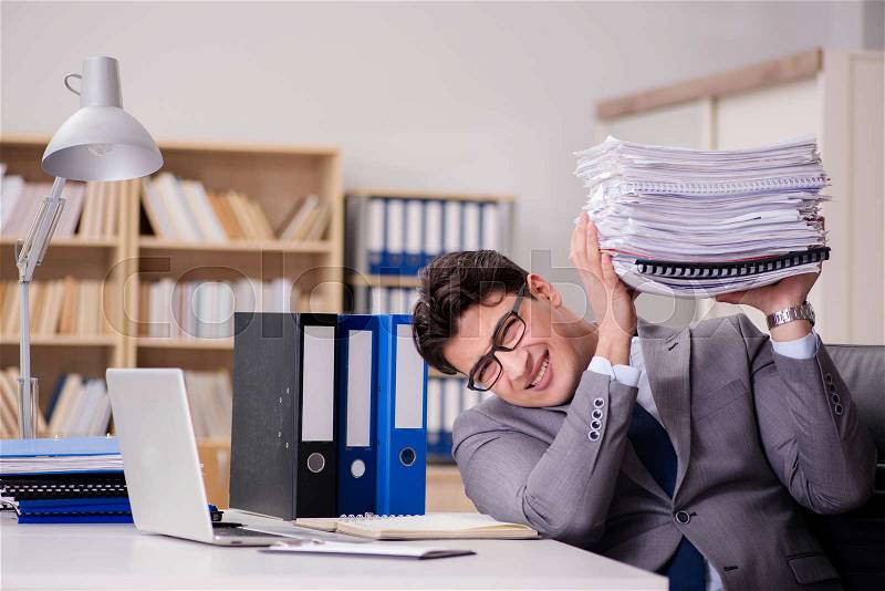 The businessman struggling with stacks of papers, stock photo