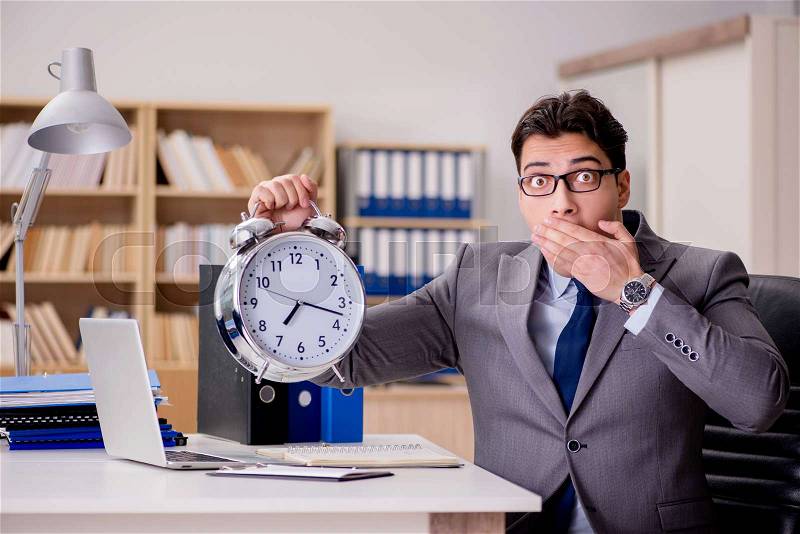 The businessman with clock failing to meet deadlines, stock photo