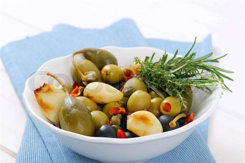 Bowl of pickled olives, capers, caper berries and garlic, stock photo