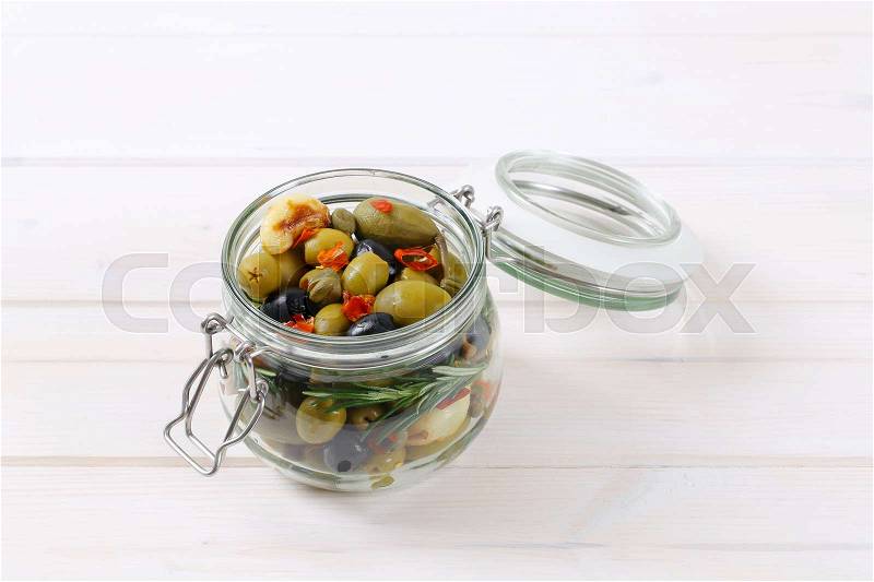 Jar of pickled olives, capers, caper berries and garlic, stock photo